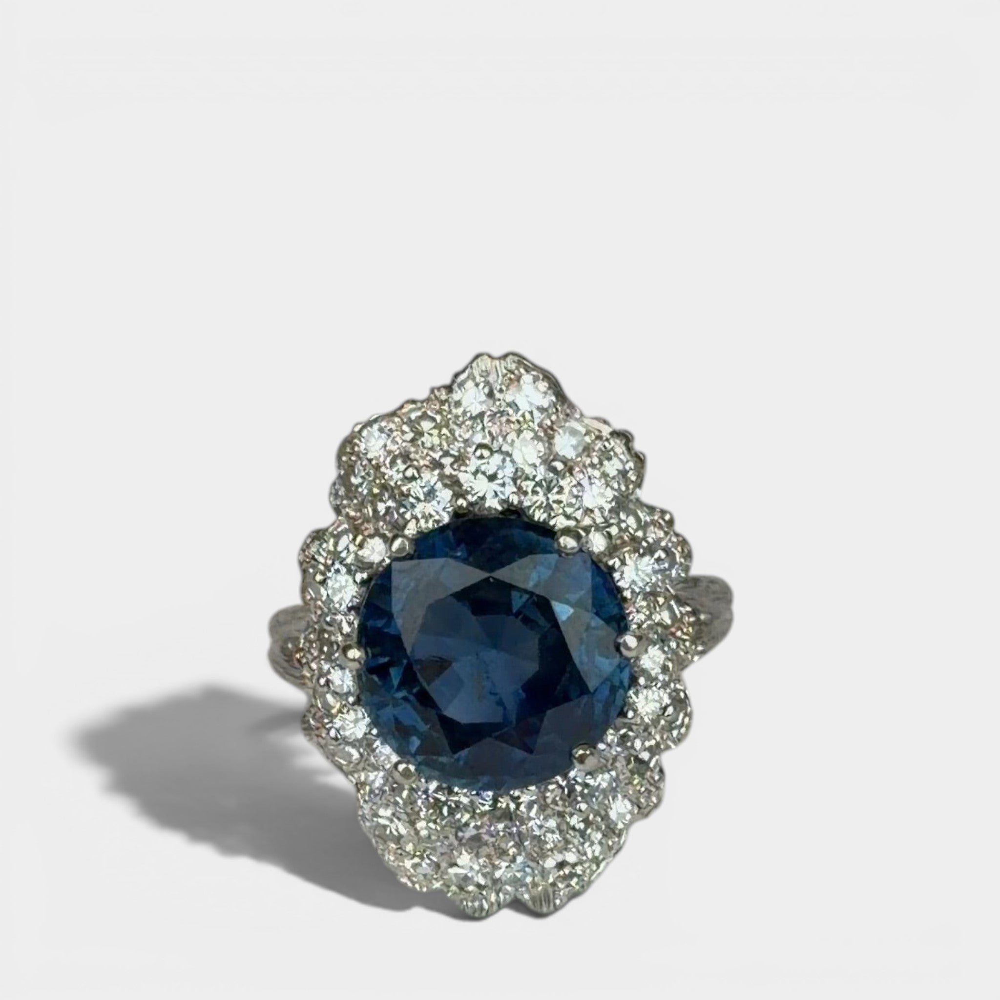 Ring «Entourage» in white gold 750 with 1 sapphire ca. 7.5ct, 18 diamonds brilliant cut ca. G-H/si 0.70ct, 55 dia-monds eight facet cut 8/8 ca. G-H/si 1.40ct, fingersize: 57,
weight: 13.4g