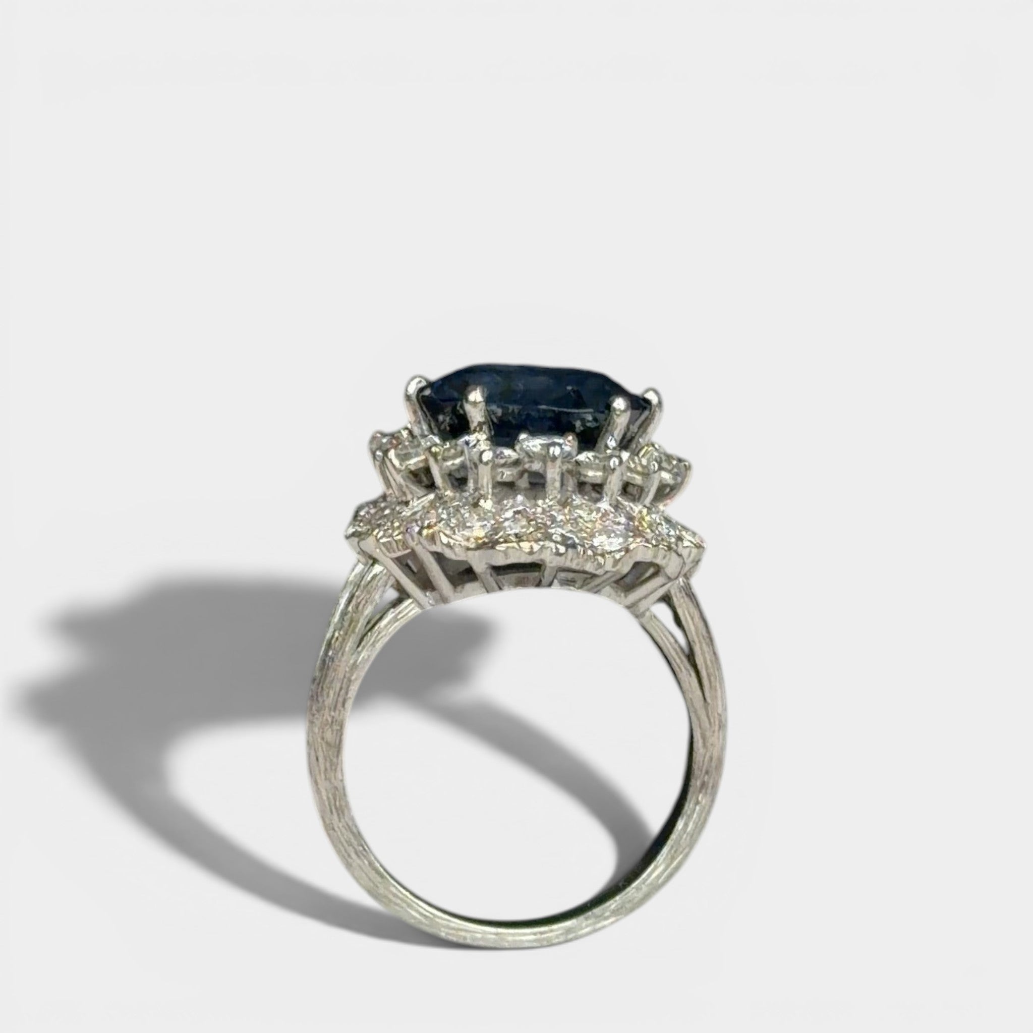 Ring «Entourage» in white gold 750 with 1 sapphire ca. 7.5ct, 18 diamonds brilliant cut ca. G-H/si 0.70ct, 55 dia-monds eight facet cut 8/8 ca. G-H/si 1.40ct, fingersize: 57,
weight: 13.4g