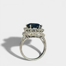 Ring «Entourage» in white gold 750 with 1 sapphire ca. 7.5ct, 18 diamonds brilliant cut ca. G-H/si 0.70ct, 55 dia-monds eight facet cut 8/8 ca. G-H/si 1.40ct, fingersize: 57,
weight: 13.4g